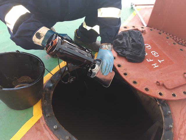 Sampling can lowered into a fuel oil tank through the manhole